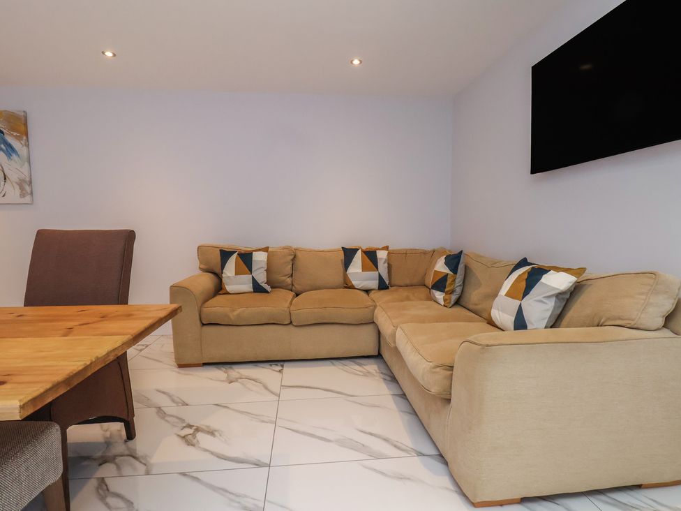 A living room with a sofa and dining table at Courtenay House Harpham near Nafferton
