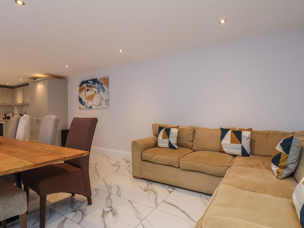 A living room with a sofa and dining area at Courtenay House in Harpham near Nafferton