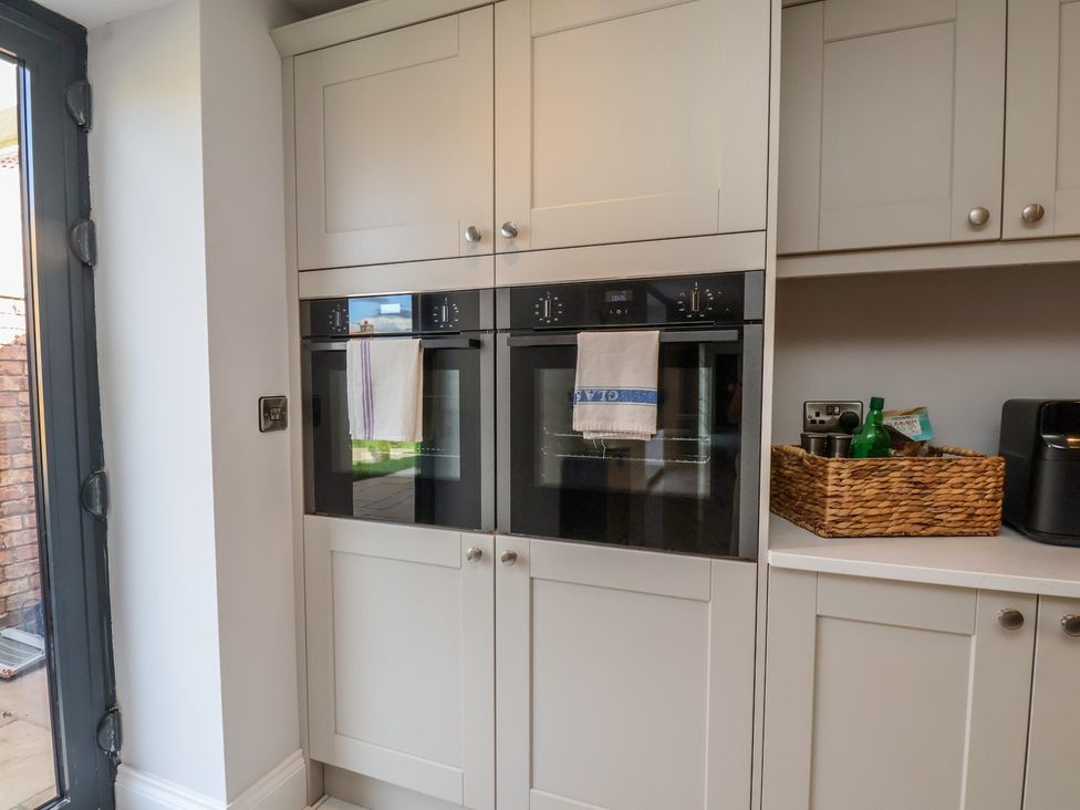 A kitchen with built-in ovens and storage cabinets at Courtenay House Harpham near Nafferton