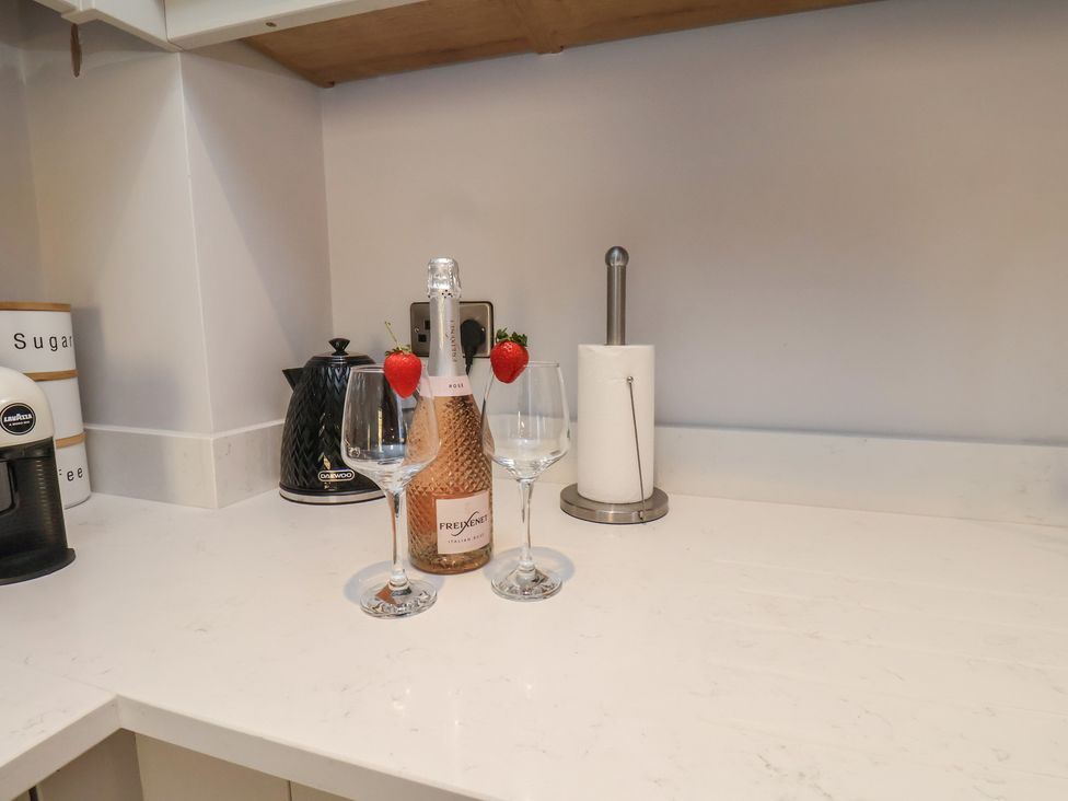A kitchen counter with a bottle and glasses at Courtenay House Harpham near Nafferton