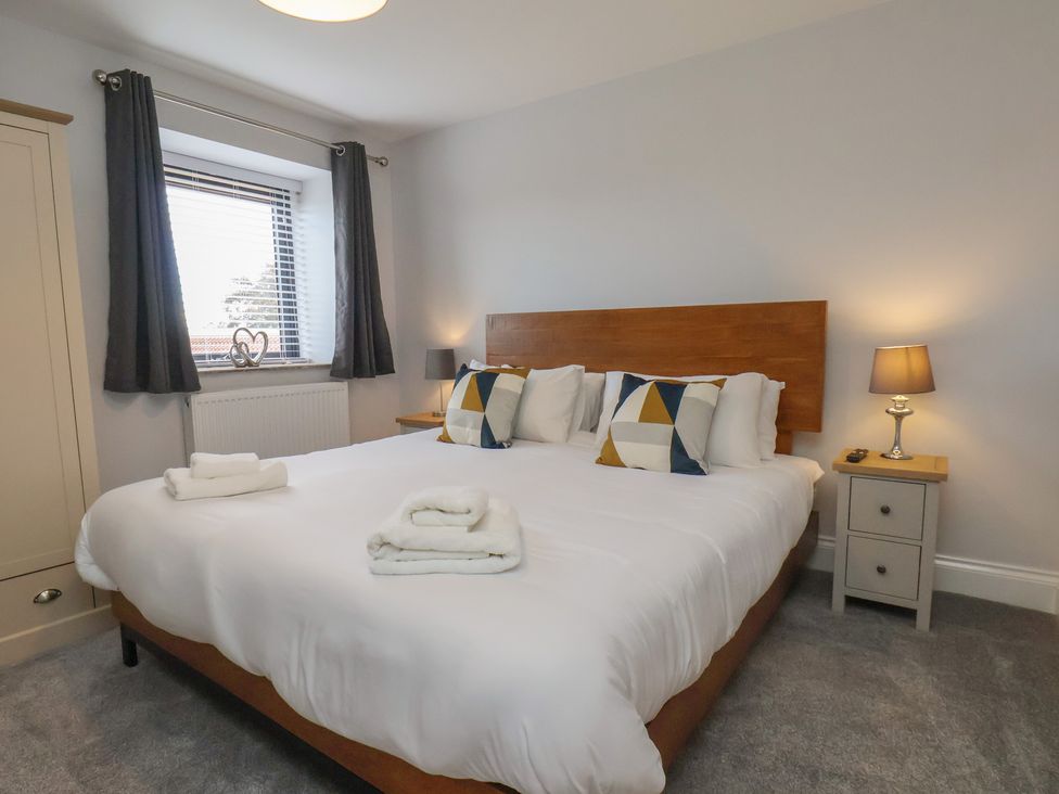 A bedroom with a double bed and bedside table at Courtenay House Harpham near Nafferton