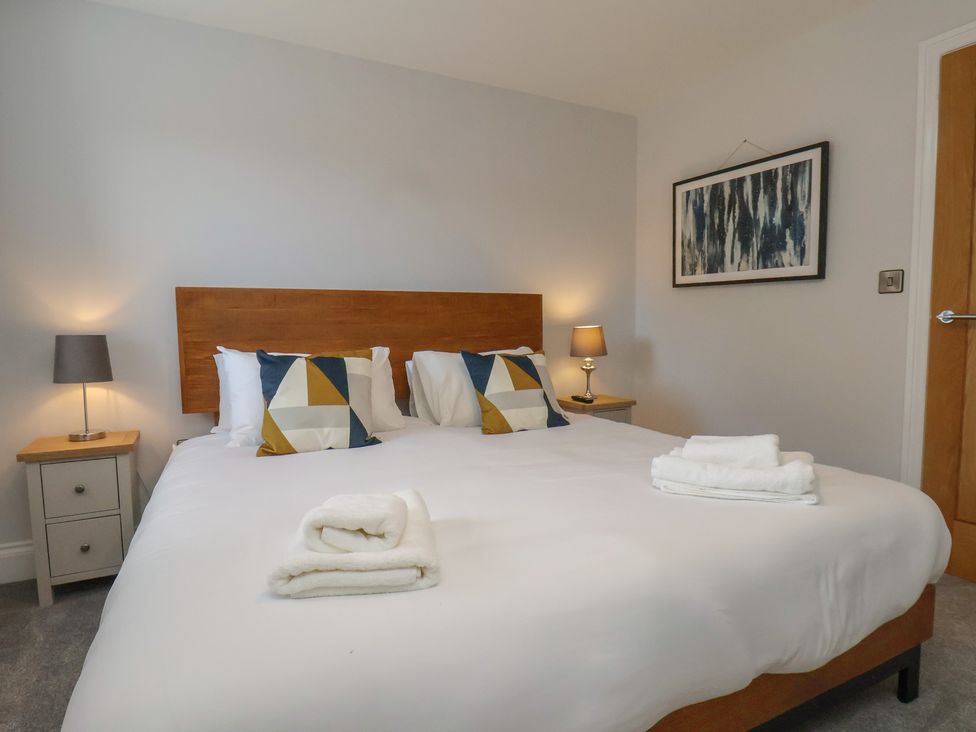 A bedroom with a bed and bedside tables at Courtenay House Harpham near Nafferton