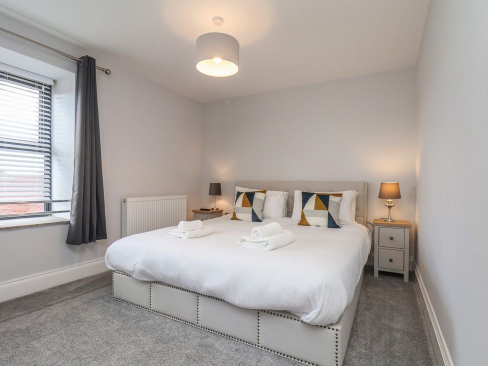 A bedroom with a bed, pillows, and a lamp at Courtenay House Harpham near Nafferton