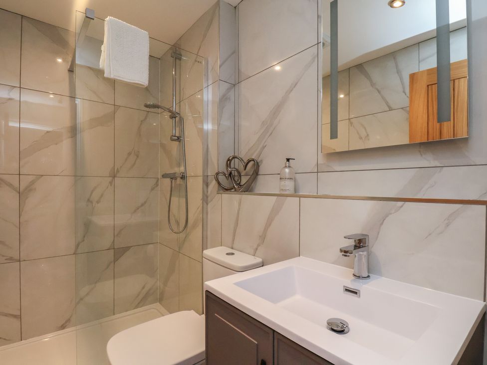 A bathroom with sink, toilet, and shower at Courtenay House in Harpham near Nafferton