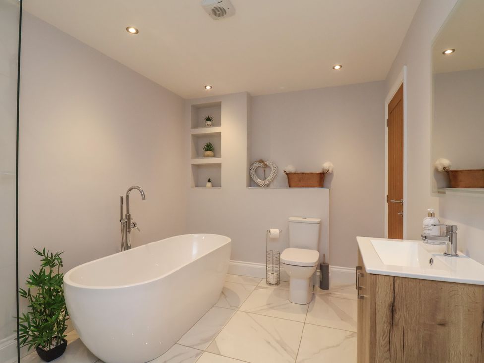 A bathroom with a bathtub and sink at Courtenay House in Harpham near Nafferton