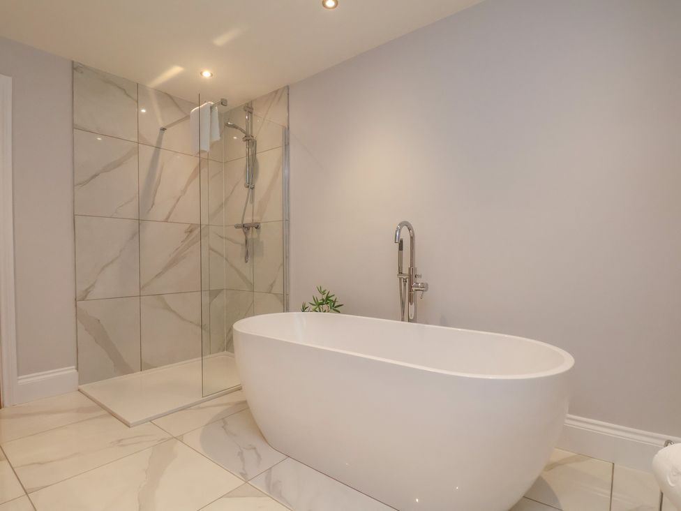 A bathroom with a bathtub and shower at Courtenay House Harpham near Nafferton