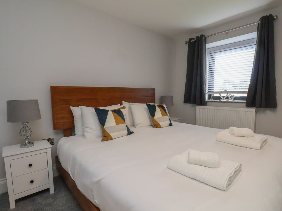 A bedroom featuring a bed with pillows and a nightstand at Courtenay House Harpham near Nafferton