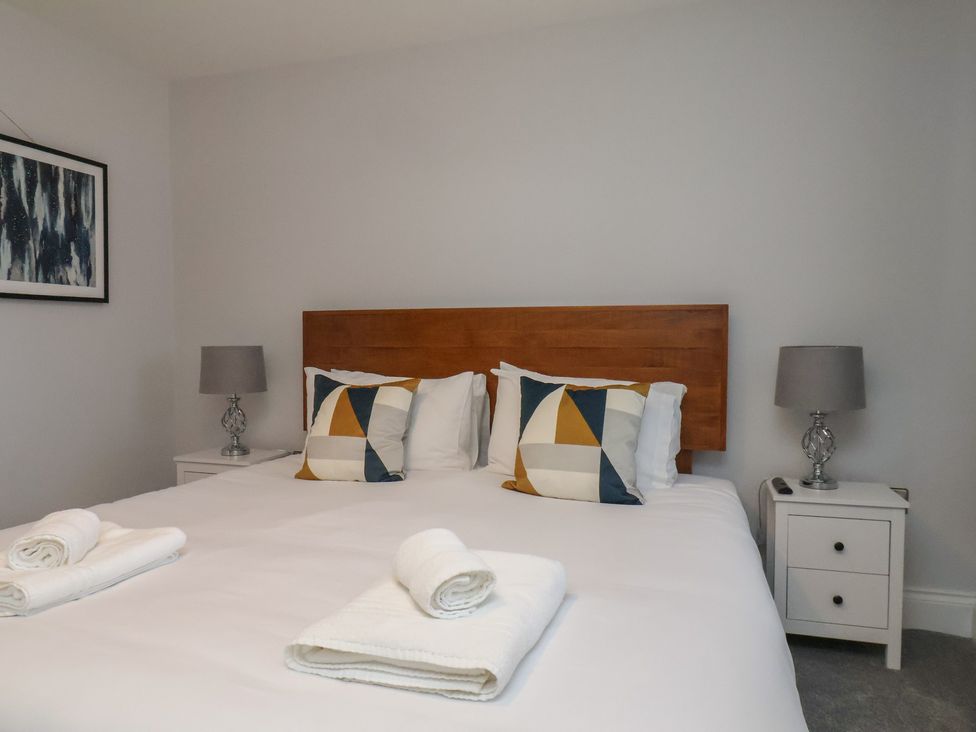 A bedroom with a bed and side tables at Courtenay House in Harpham near Nafferton