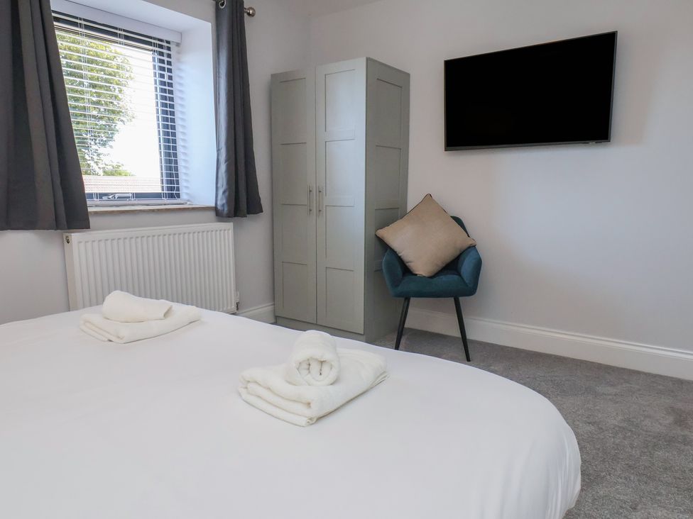 A bedroom with a bed and wardrobe at Courtenay House Harpham near Nafferton