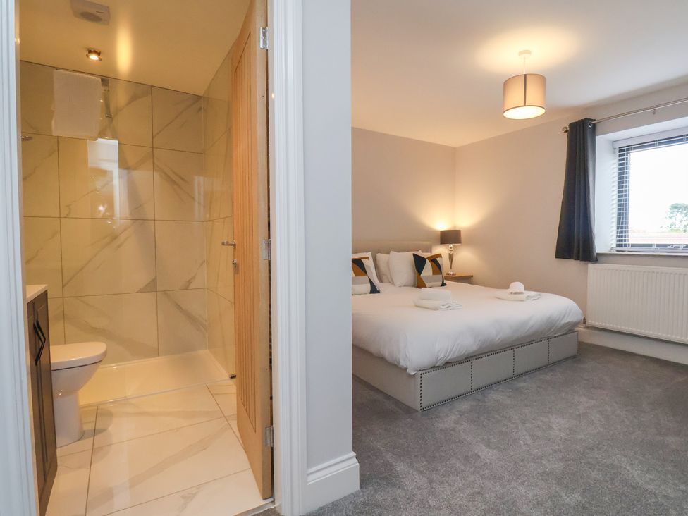 A bedroom with an ensuite bathroom at Courtenay House Harpham near Nafferton