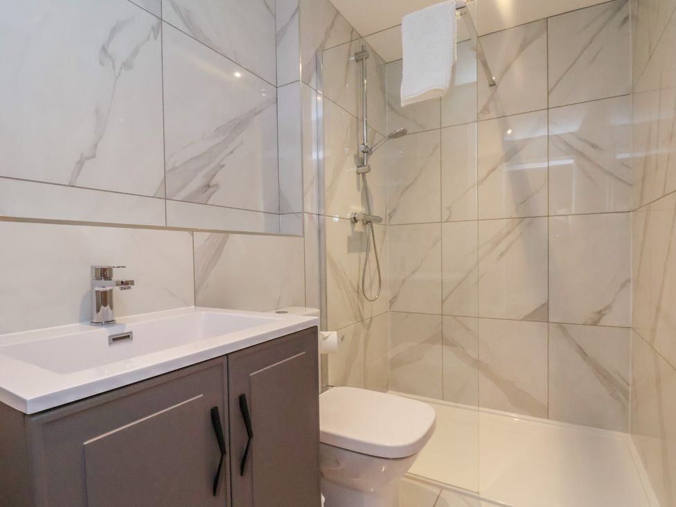 A bathroom with a shower, sink, and toilet at Courtenay House, Harpham near Nafferton