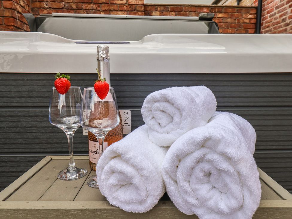 A hot tub with glasses and towels at Courtenay House near Harpham
