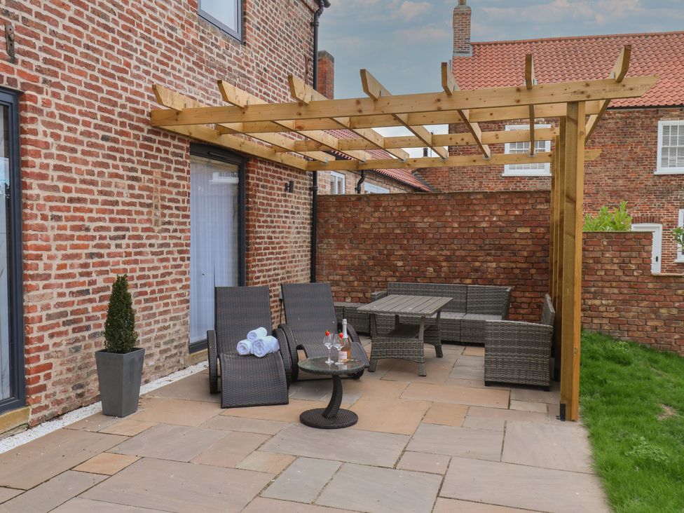 An outdoor seating arrangement with a table and potted plant at Courtenay House Harpham near Nafferton