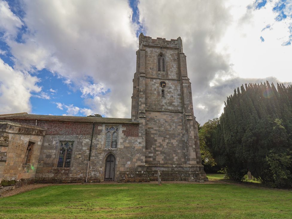 A church tower with clock and windows at Courtenay House in Harpham near Nafferton