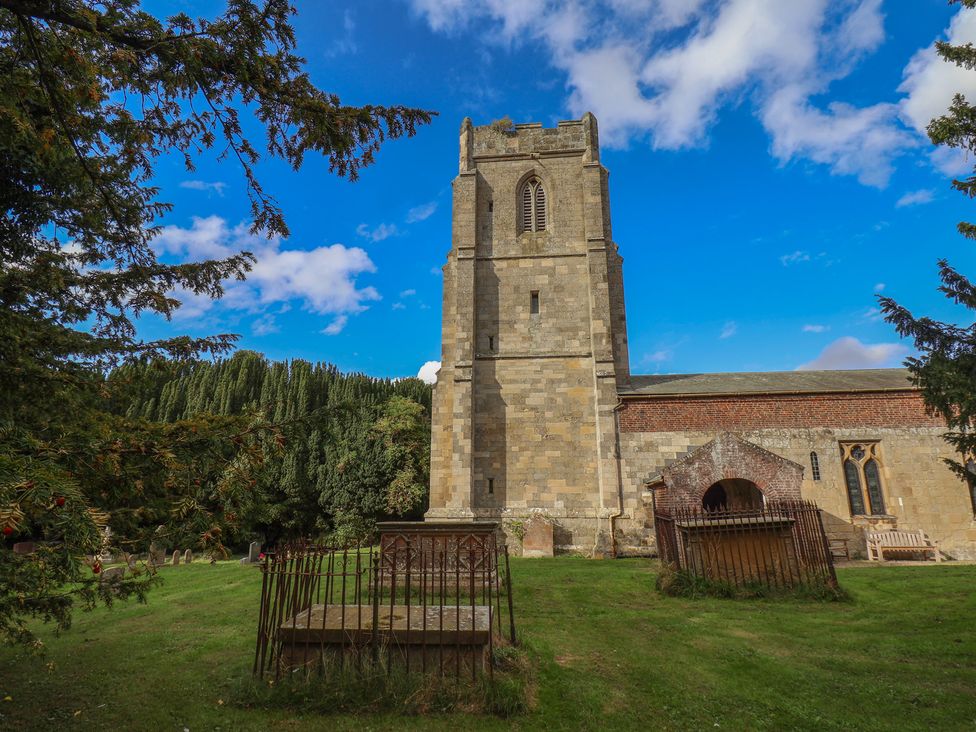 A church with a bell tower and graveyard at Courtenay House Harpham near Nafferton