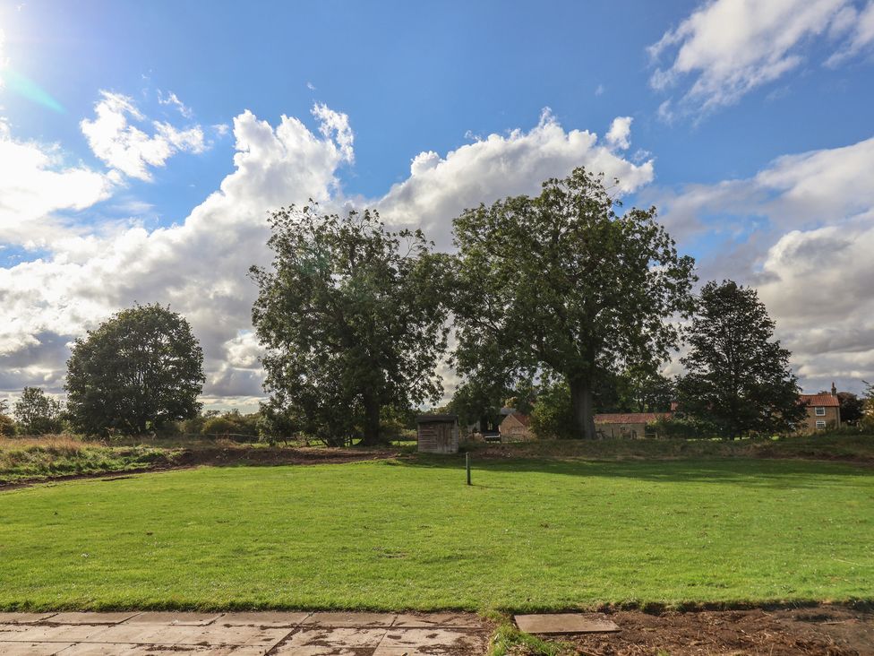 A garden with grass and trees at Courtenay House Harpham near Nafferton