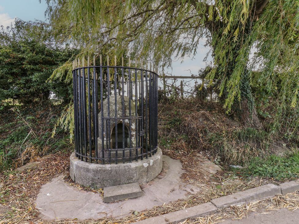 A stone well surrounded by a metal railing in Harpham near Nafferton