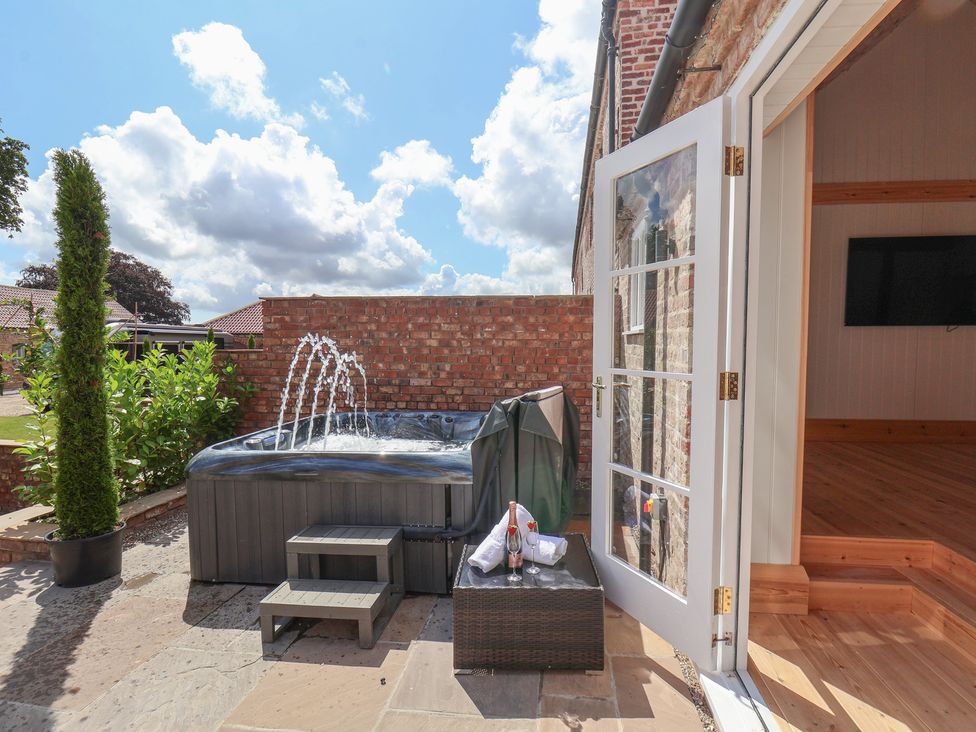 An outdoor space with a hot tub and steps at Harpham Manor House in Harpham near Nafferton
