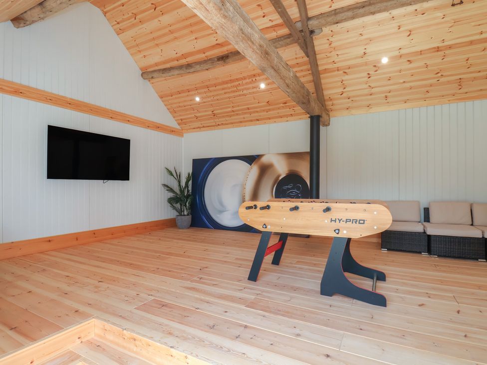 A recreation room with a foosball table and television at Harpham Manor House in Harpham near Nafferton