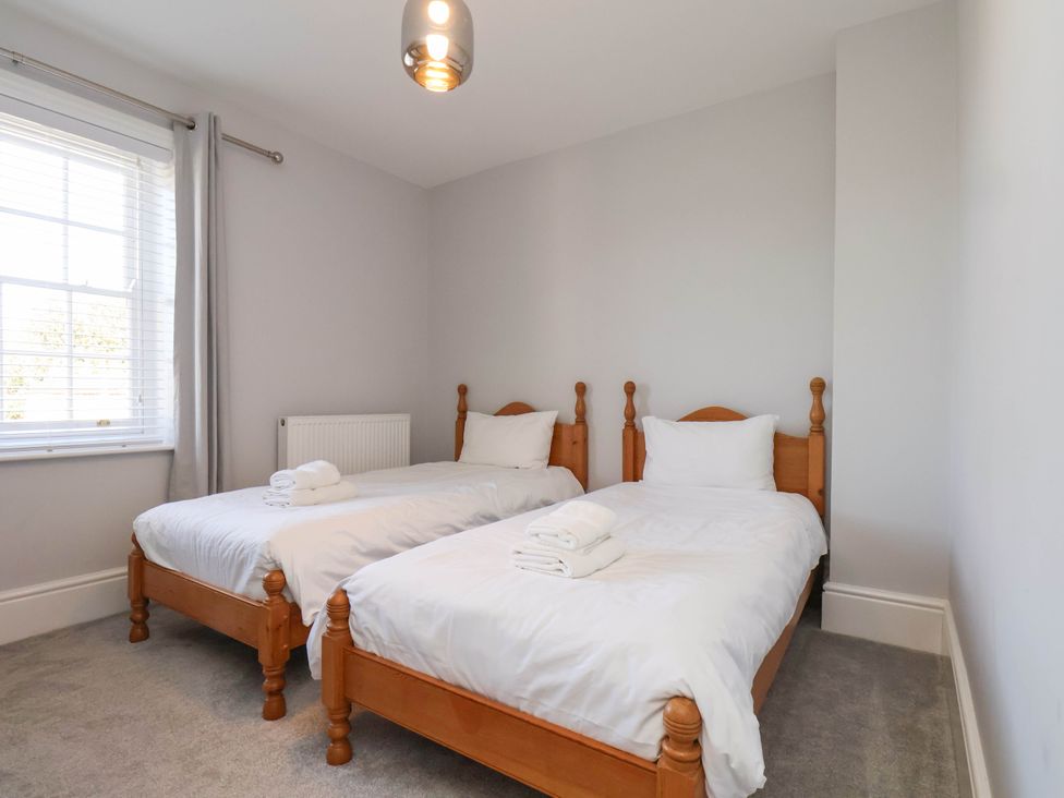 A bedroom with two single beds and a window at Harpham Manor House Nafferton