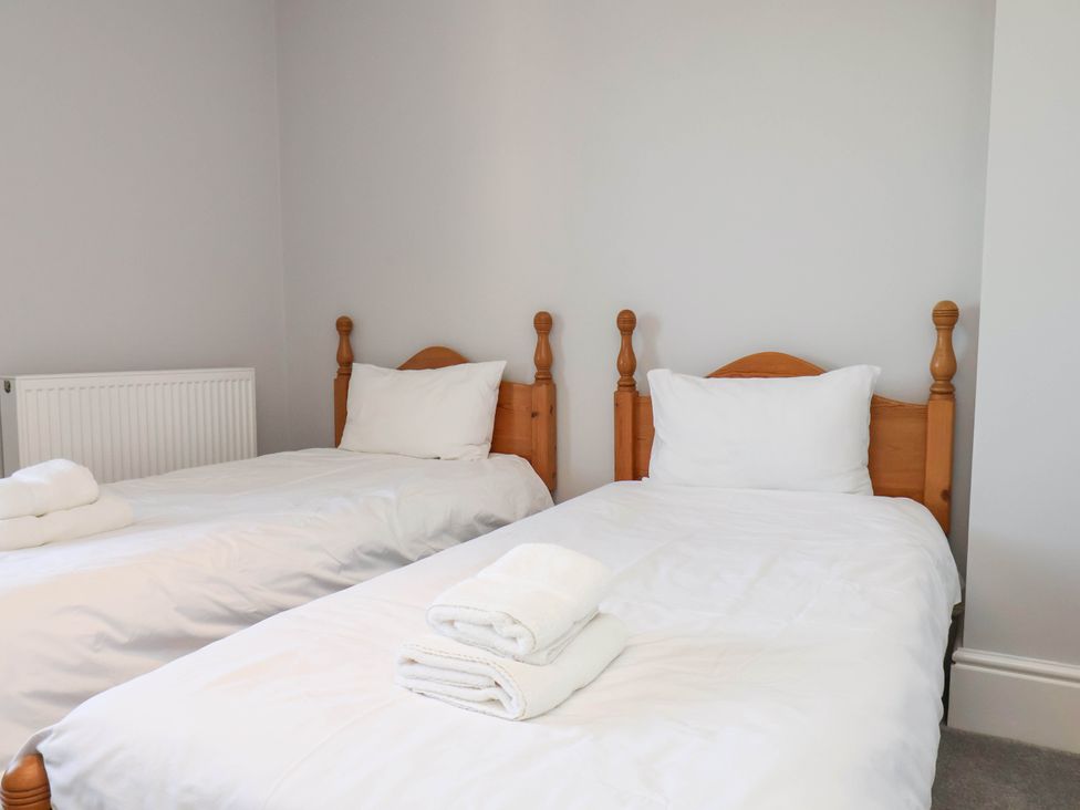 A bedroom with two single beds and towels at Harpham Manor House in Nafferton