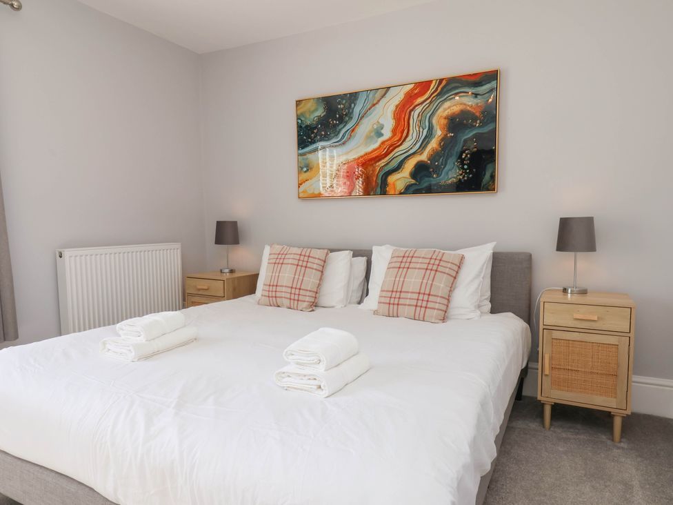 A bedroom with a double bed and artwork at Harpham Manor House in Nafferton