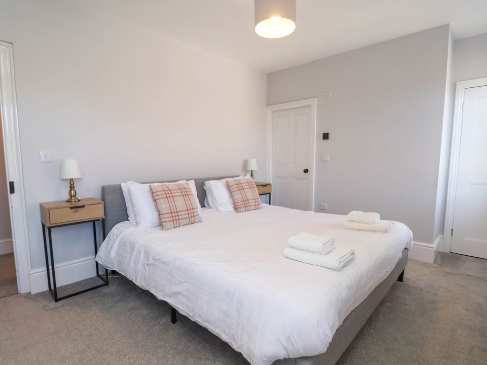 A bedroom with a large bed and side tables at Harpham Manor House in Nafferton