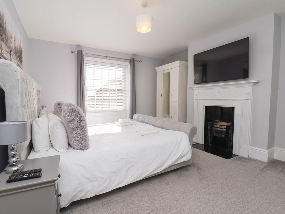 A bedroom with a bed and wardrobe at Harpham Manor House in Nafferton