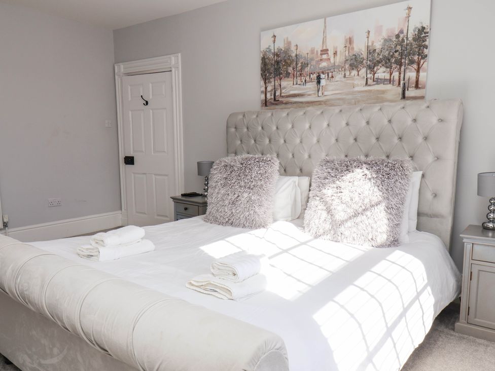 A bedroom with a bed and two bedside tables at Harpham Manor House in Nafferton