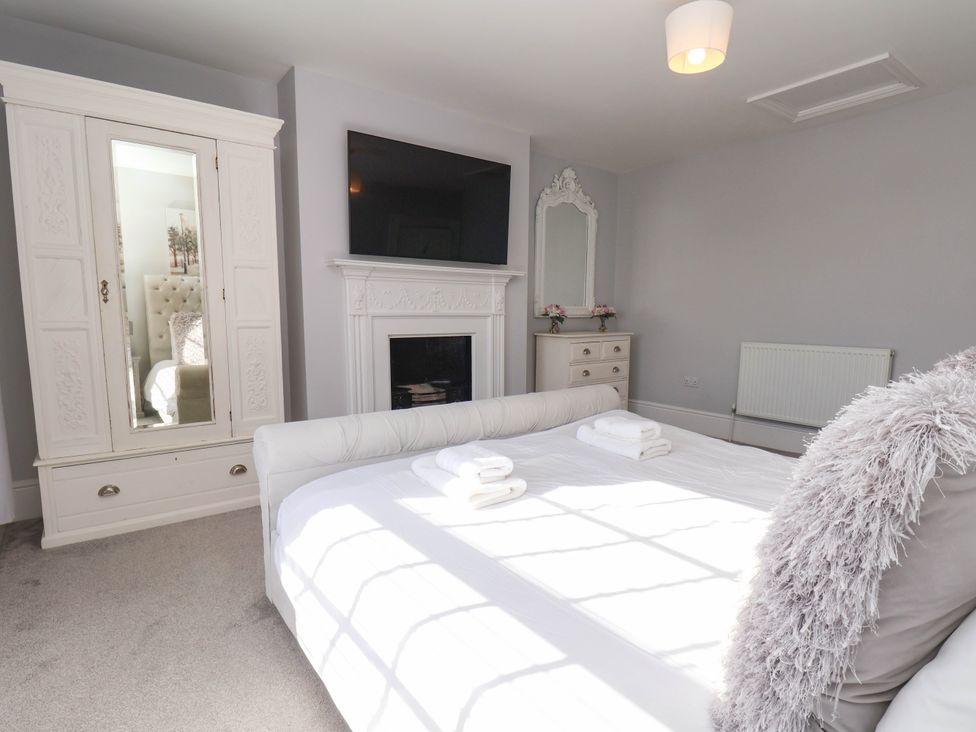 A bedroom with a bed and wardrobe at Harpham Manor House Nafferton