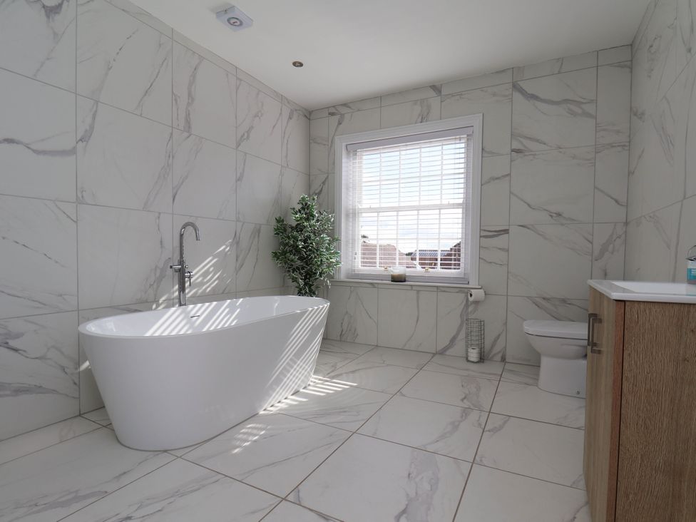 A bathroom with a bathtub and toilet at Harpham Manor House Nafferton