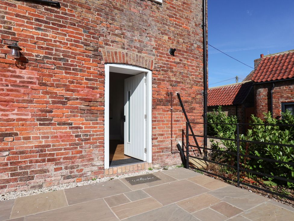 An entrance with a door and brick wall at Harpham Manor House in Nafferton