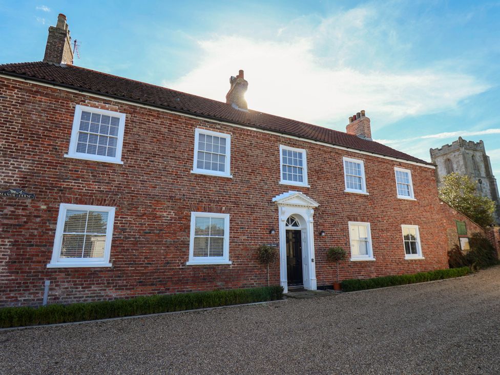 A brick house with windows and a door at Harpham Manor House in Nafferton