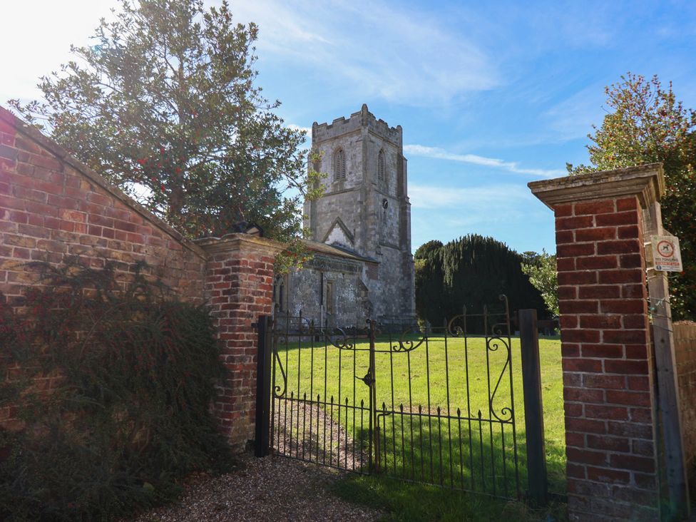 A church viewed through a gated entrance at Harpham Manor House in Nafferton