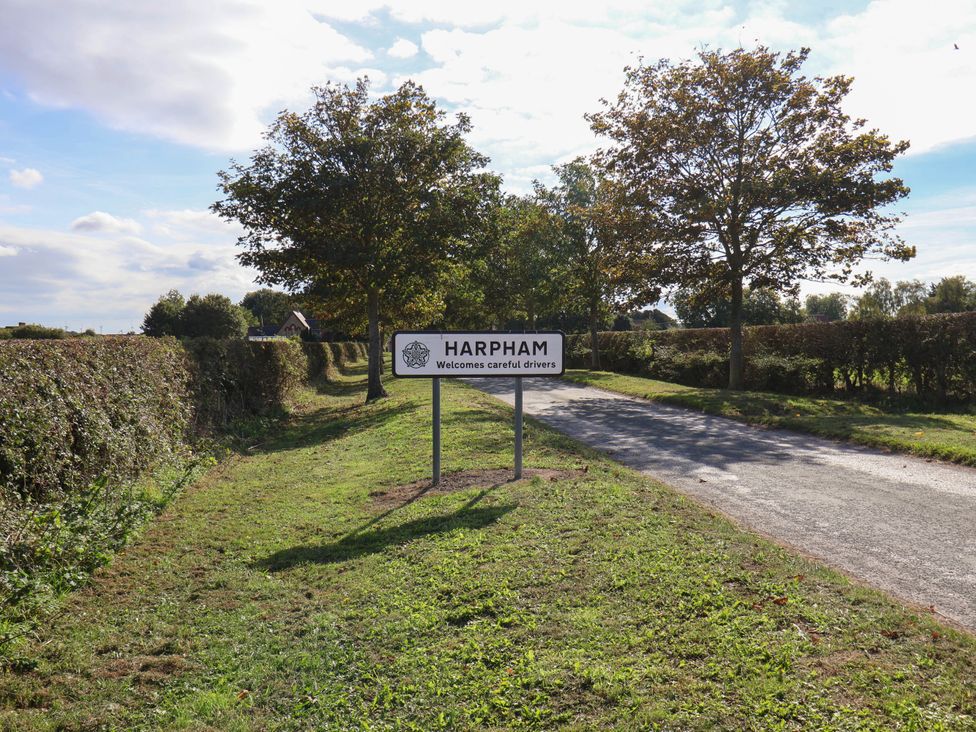 A sign for Harpham and a road surrounded by trees at Harpham Manor House, Nafferton