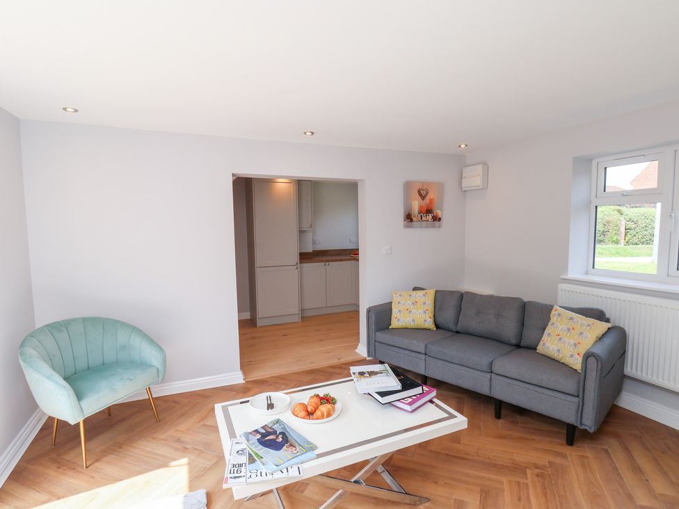 A living room with a sofa and armchair at Manor Cottage in Harpham near Nafferton