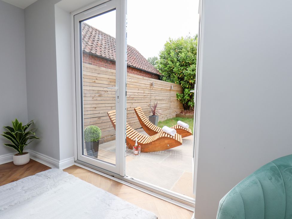 A room with a sliding door leading to a garden at Manor Cottage in Harpham near Nafferton