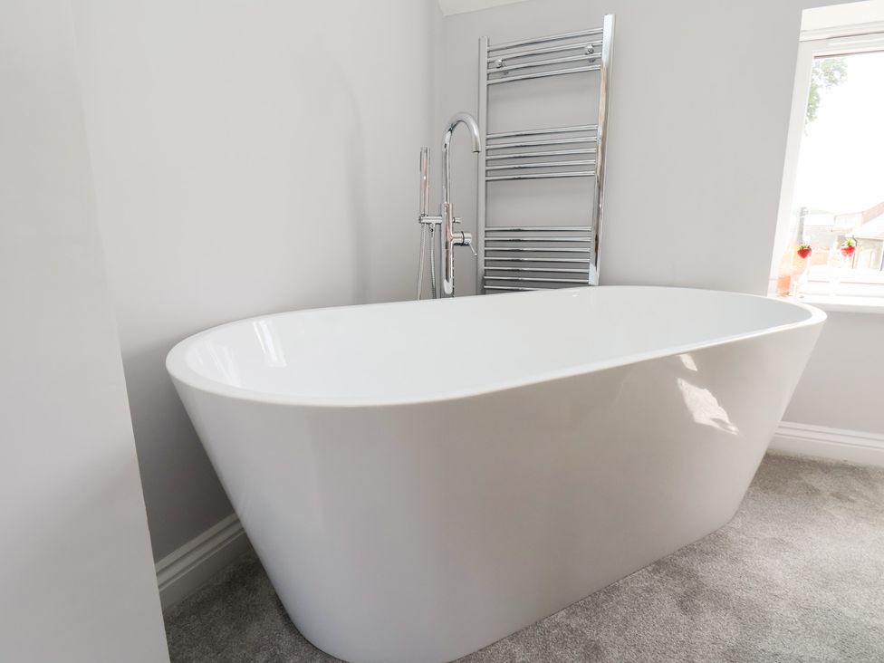 A bathroom with a freestanding bathtub and a towel radiator at Manor Cottage Harpham near Nafferton
