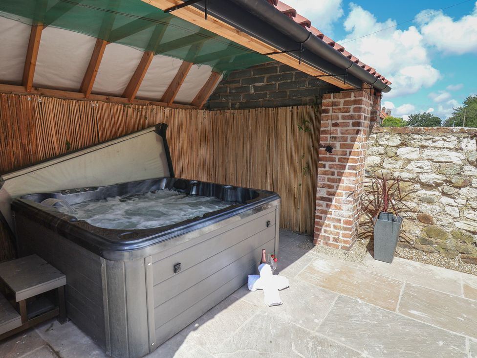 An outdoor area with a hot tub and plants at Manor Cottage in Harpham near Nafferton