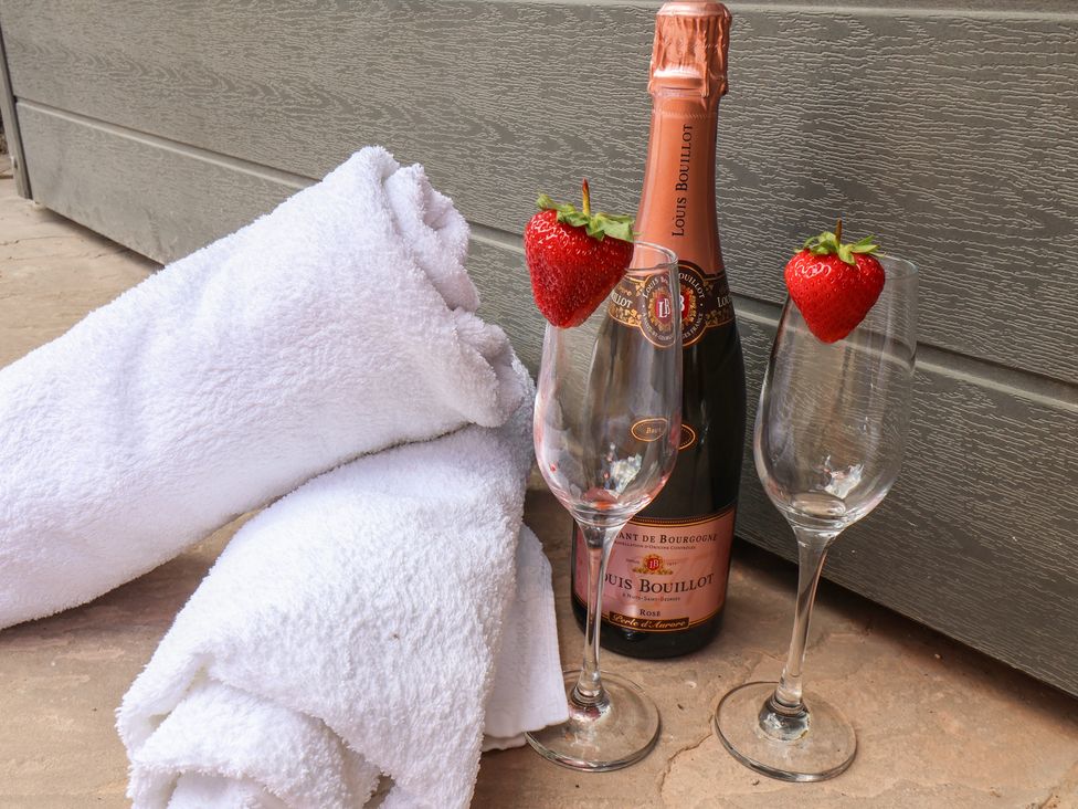Towels and champagne with glasses and strawberries at Manor Cottage Harpham near Nafferton