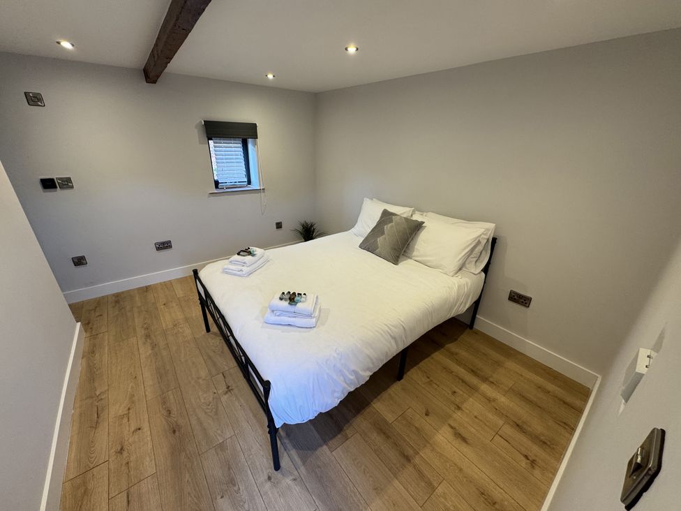 A bedroom with a bed and window at Manor Cottage in Harpham near Nafferton