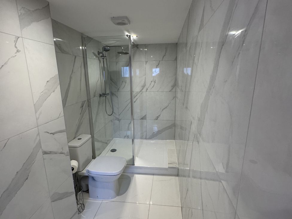 A bathroom with a shower and toilet at Manor Cottage in Harpham near Nafferton