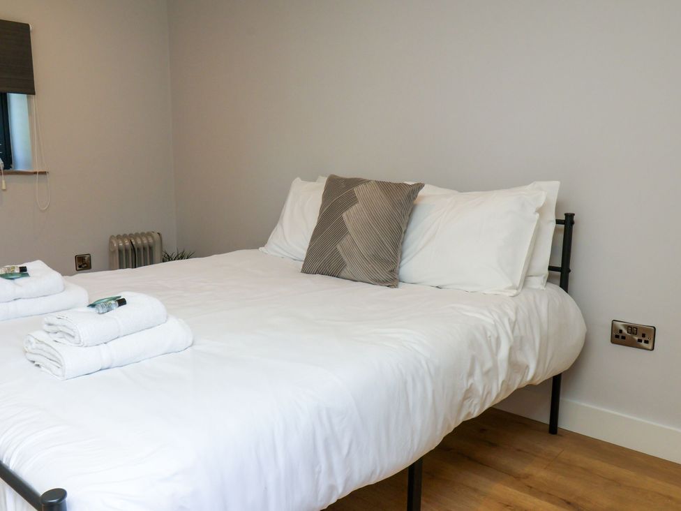 A bedroom with a bed and towels at Manor Cottage in Harpham near Nafferton
