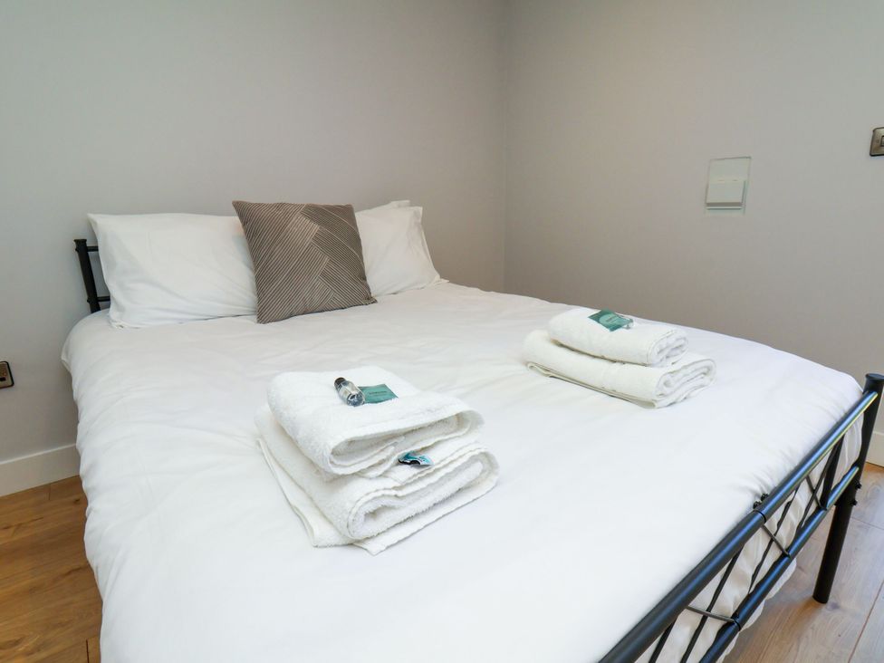 A bedroom with a double bed and towels placed on top at Manor Cottage in Harpham near Nafferton