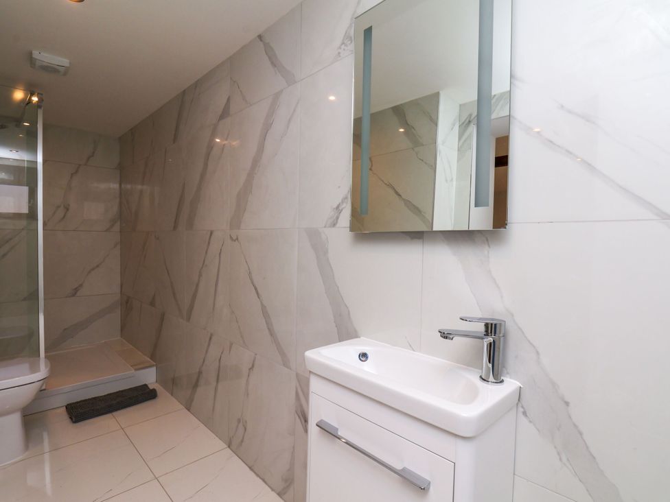 A bathroom with a shower, sink, and toilet at Manor Cottage in Harpham near Nafferton