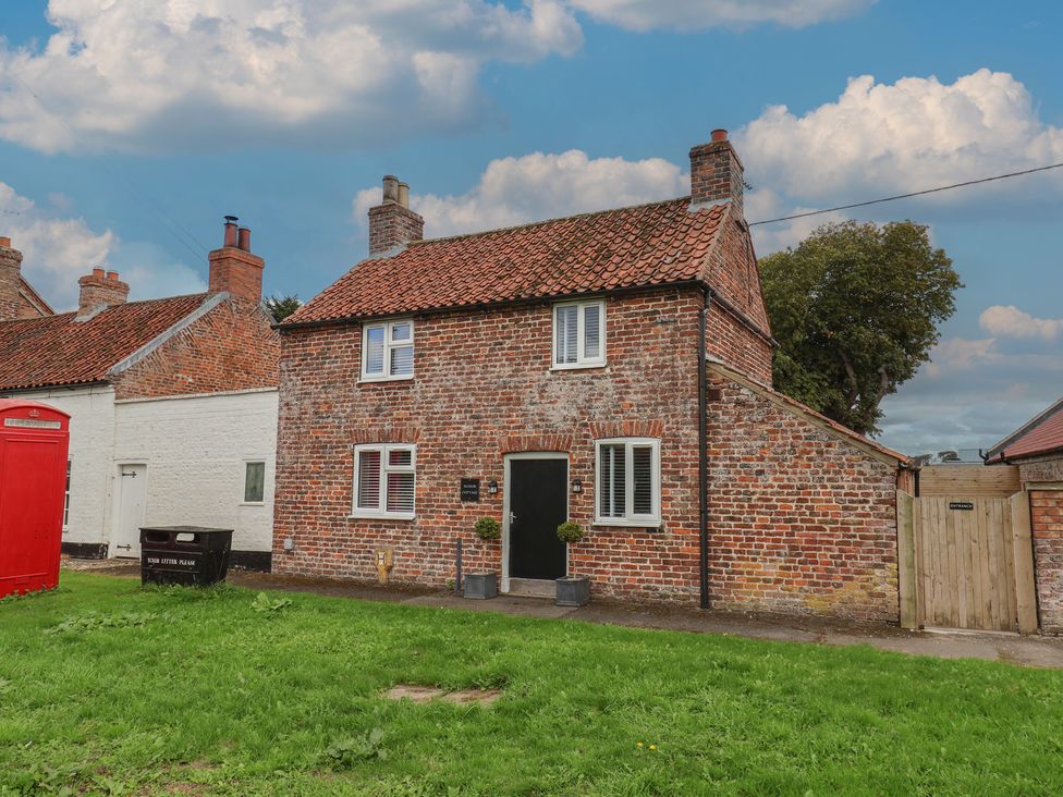 A house with a brick exterior and windows at Manor Cottage Harpham near Nafferton