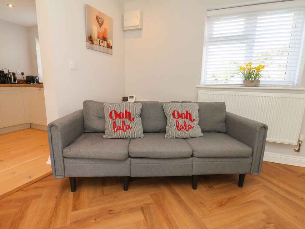 A living room with a sofa and wall art at Manor Cottage Harpham near Nafferton