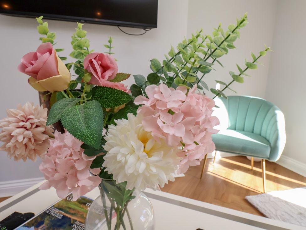 A vase of flowers and a chair at Manor Cottage Harpham near Nafferton