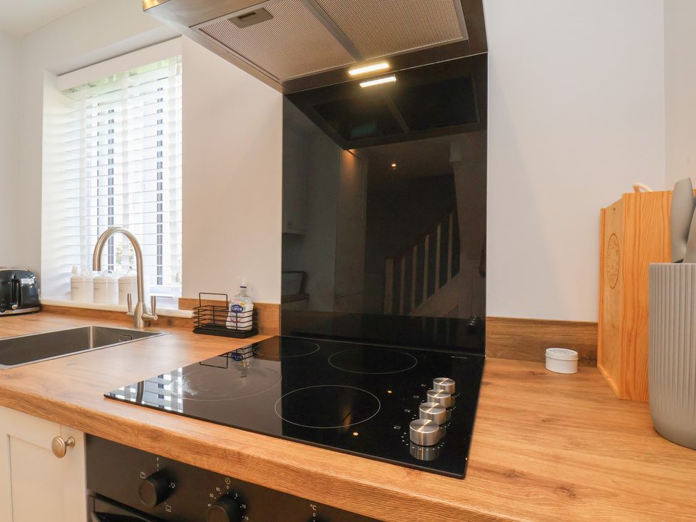 A kitchen with an induction cooktop and sink at Manor Cottage in Harpham near Nafferton
