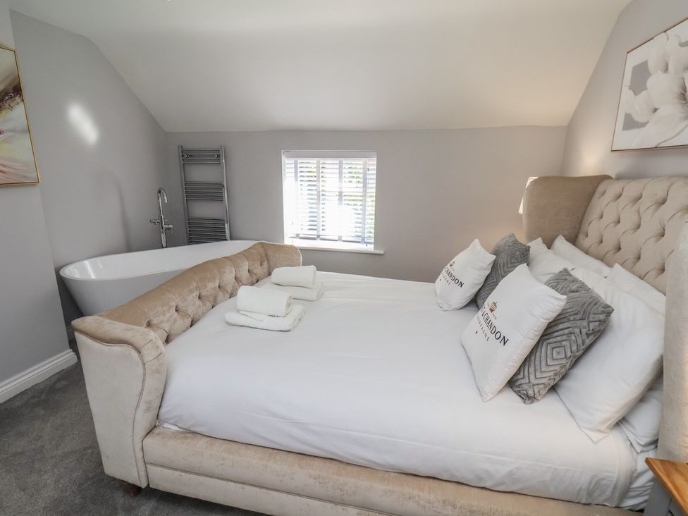 A bedroom with a bed and bathtub at Manor Cottage in Harpham near Nafferton